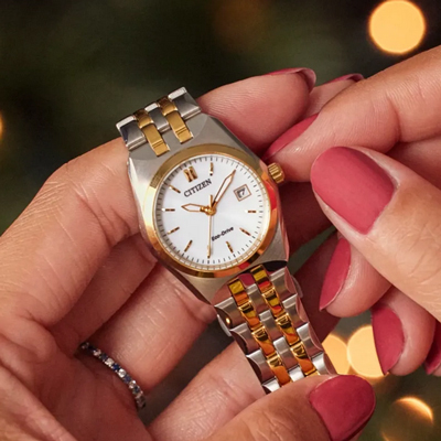 CITIZEN<sup>&reg;</sup> Ladies Corso Eco-Drive Stainless Steel Watch - This watch features a gold and silver-tone stainless steel bracelet and case with a 3-hand white dial and date indicator. Other features include luminous hands and gold-tone markers, fold-over clasp closure with hidden push buttons and it's water resistant to 100 meters. Eco-Drive technology, so it is sustainably powered by any light and will never need a battery.